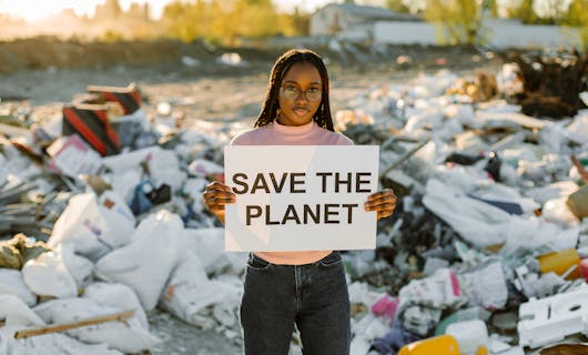 Frau hält ein Schild mit &quotSave the planet" hoch